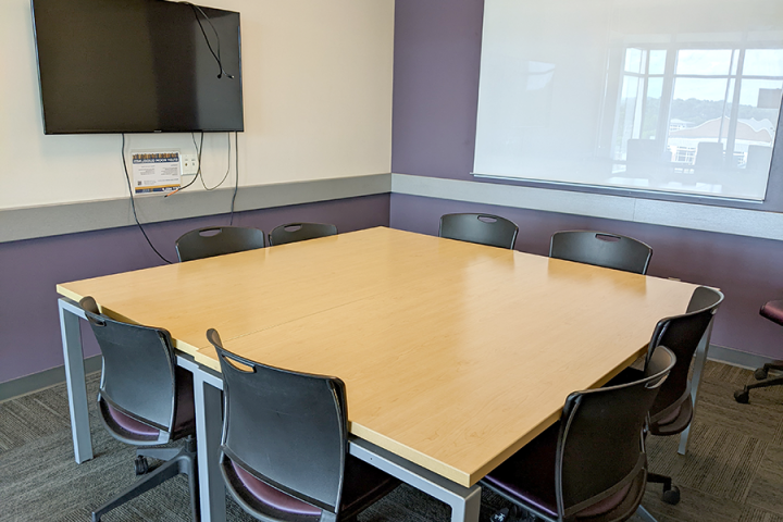 Photograph of a medium study room showing whiteboard, LCD screen and furniture arrangement